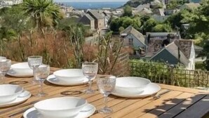 A table set for dining with a view of a coastal town. - Sea View House in Cornwall Fishing Village (St Austell)
