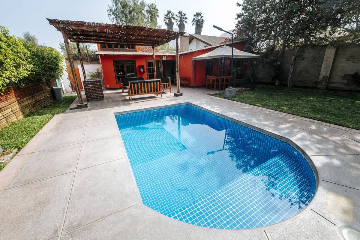 Ein rechteckiger Swimmingpool mit blauen Fliesen, umgeben von einer Beton-Terrasse.