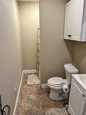 A small bathroom with a toilet, a sink, and a cabinet. - Small Cozy Quite House (Wylie)