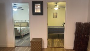 A room with a bed, a small table, and a ceiling fan. - Small Cozy Quite House (Wylie)