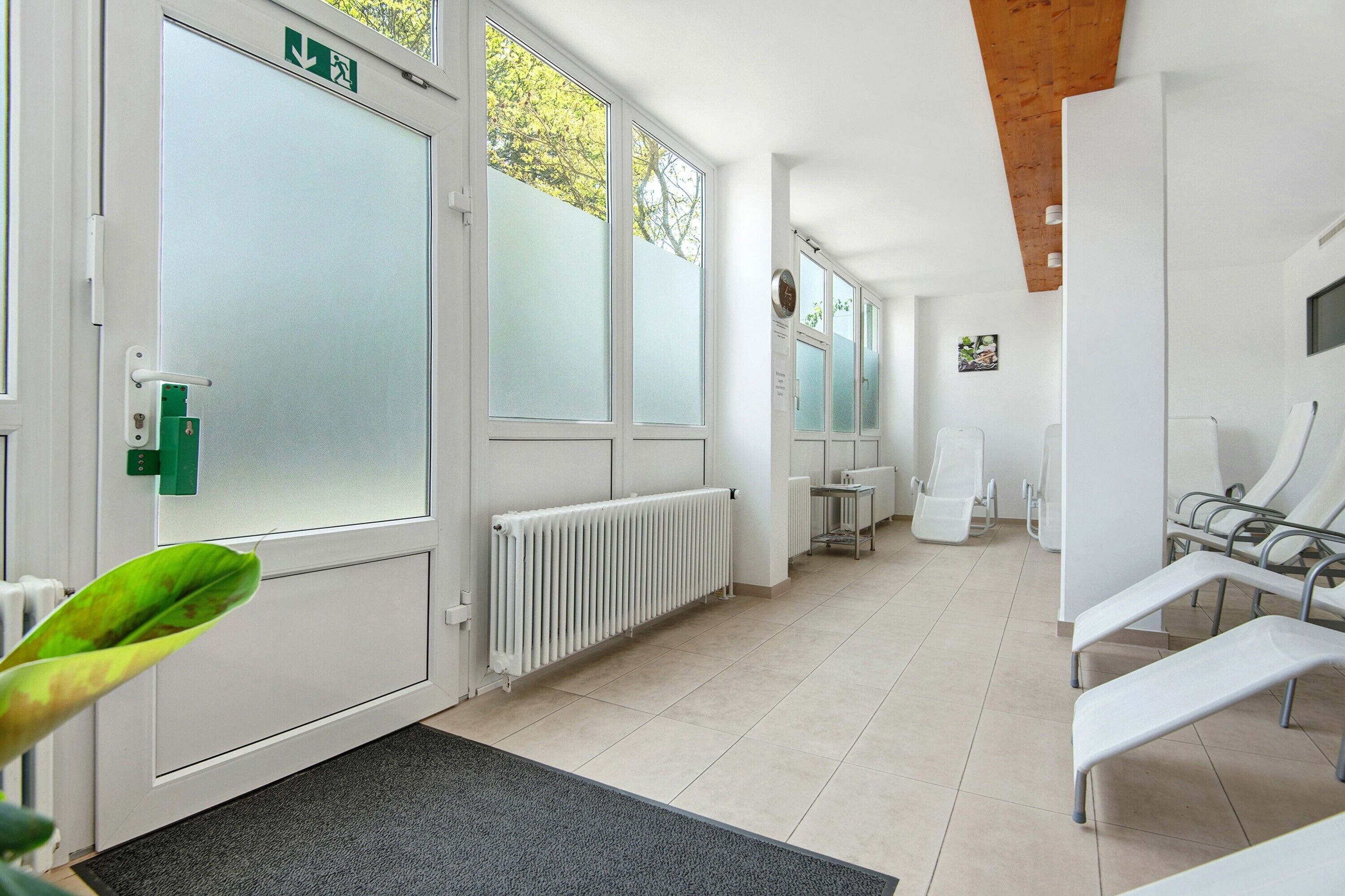 Pasillo con mostrador de recepción, zona de espera y puerta con vidrio esmerilado.