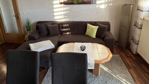 A living room with a brown sofa, two armchairs, a coffee table, and a painting on the wall. - Holiday Apartment "Ferienwohnung Köppl" with Terrace (LAM)