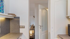 A modern kitchen with granite countertops, a built-in oven, and a white door leading to a bedroom. - Holiday Apartment "Anette" with Mountain View, Balcony & Wi-Fi (Garmisch-Partenkirchen)