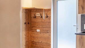 Un mur en bois avec une pancarte indiquant «Bienvenue», une porte et un petit coin cuisine.