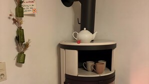 Ein gemütliches Zimmer mit Kaminofen, einem dekorativen Hirschgeweih und einem Schild mit deutschem Text.