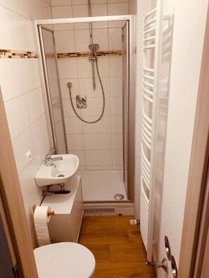 A small bathroom with a shower, toilet, and sink. - Apartment "Felix Living 1" with Wi-Fi (Passau)
