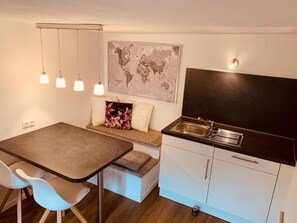 Eine kleine Küche mit Essbereich, einer Weltkarte an der Wand und einem kleinen Spülbecken.