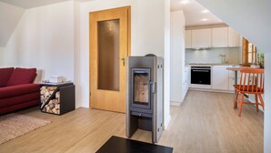 Un espace de vie compact comprenant une cheminée, une cuisine et un coin repas.