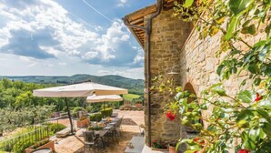 A patio with outdoor furniture and umbrellas, surrounded by stone walls and greenery. - Lamore di Carla by Interhome (Greve in Chianti)