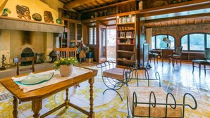 A spacious room with a wooden ceiling, a fireplace, a large wooden table, and a bookshelf. - Lamore di Carla by Interhome (Greve in Chianti)