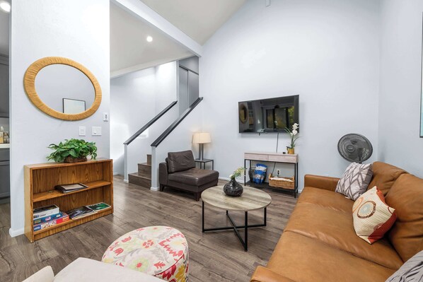A modern living room with a sofa, coffee table, and a bookshelf. - Capitola Hideaway- Dog-friendly (Capitola)