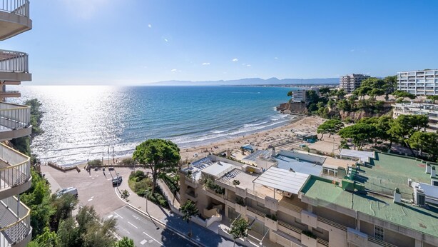 Blick auf die Küste mit Strand, einer Straße und Gebäuden.