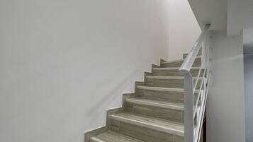 Una escalera con escalones de madera y paredes blancas.