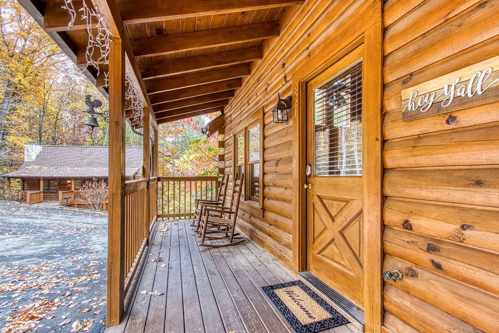 A wooden cabin with a porch, rocking chairs, and a 'Key Fall' sign.