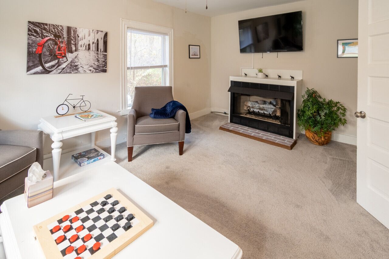 Cozy living room with a full‑size pull‑out sofa, a gas fireplace, and a selection of games — the perfect spot to unwind after exploring the Capital Trail.