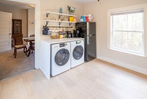 Convenient laundry facilities with washing machines and a refrigerator.