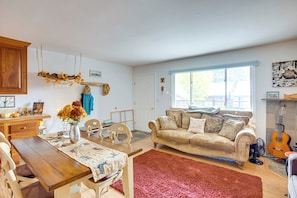 Una sala de estar acogedora con una mesa de comedor de madera, un sofá y una alfombra roja.