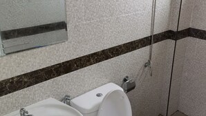A bathroom with a white sink, toilet, and shower. - YYK Hostel 24 (Nakhon Chai Si)