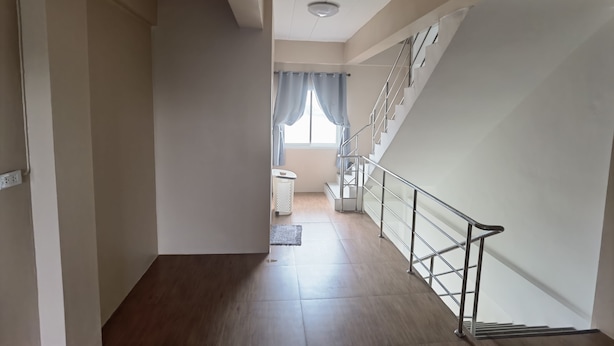 A staircase with a metal handrail leading to a landing. - YYK Hostel 24 (Nakhon Chai Si)