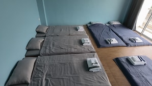 A room with multiple massage beds arranged in a row, each with a towel and pillow. - YYK Hostel 24 (Nakhon Chai Si)
