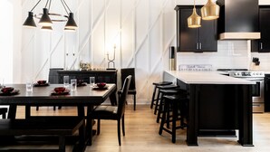 A modern kitchen with black cabinetry, a central island, and pendant lighting.