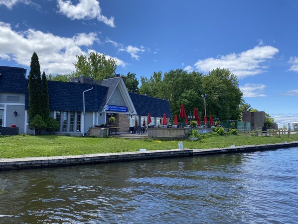 A waterfront restaurant with outdoor seating and a view of the water.