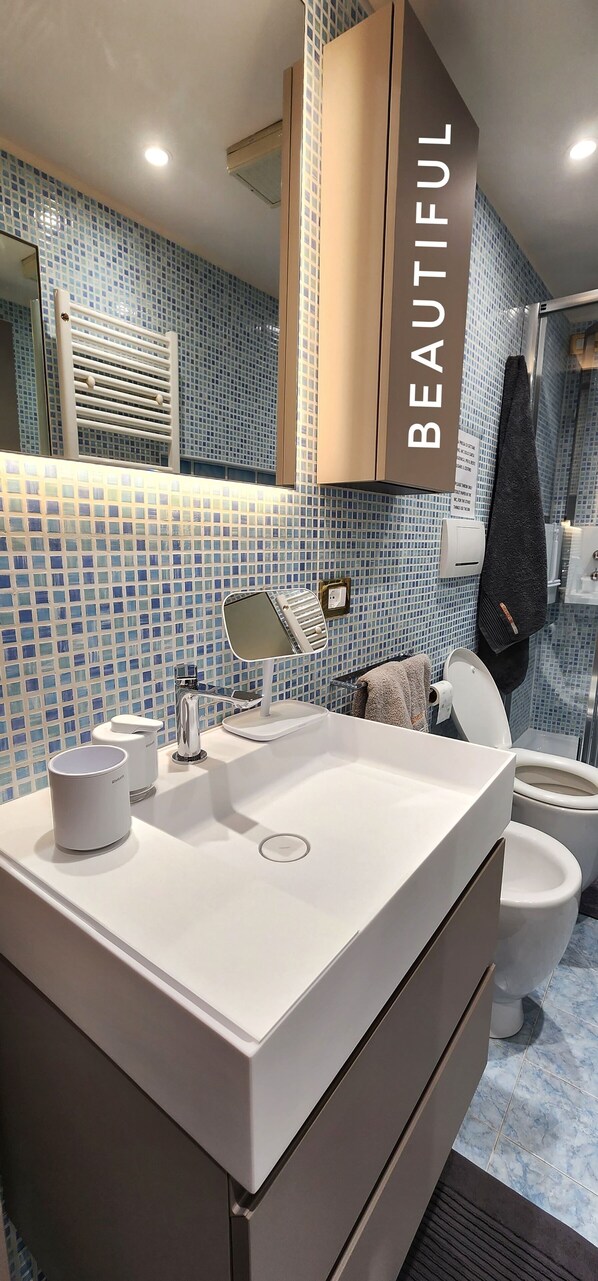 Een douche, een haardroger, een bidet, handdoeken