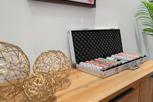 A wooden counter with a fabric case containing patterned fabric rolls, a gold decorative sphere, and a foam-lined fabric case.