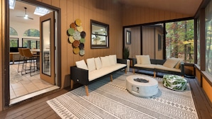 A modern living room with a sofa, two armchairs, a coffee table, and a patterned rug. - Modern Poconos Game House, Hot Tub, Fire Pit (East Stroudsburg)