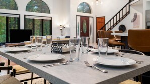 A dining area with a long table set for four, clear glasses, and cutlery. - Modern Poconos Game House, Hot Tub, Fire Pit (East Stroudsburg)