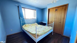 Une chambre à coucher avec un lit, un bureau et une armoire.