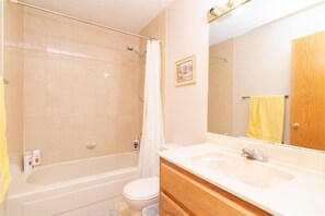 A bathroom with a bathtub, toilet, and sink. - Calgary Hawkwood service resident (Calgary)