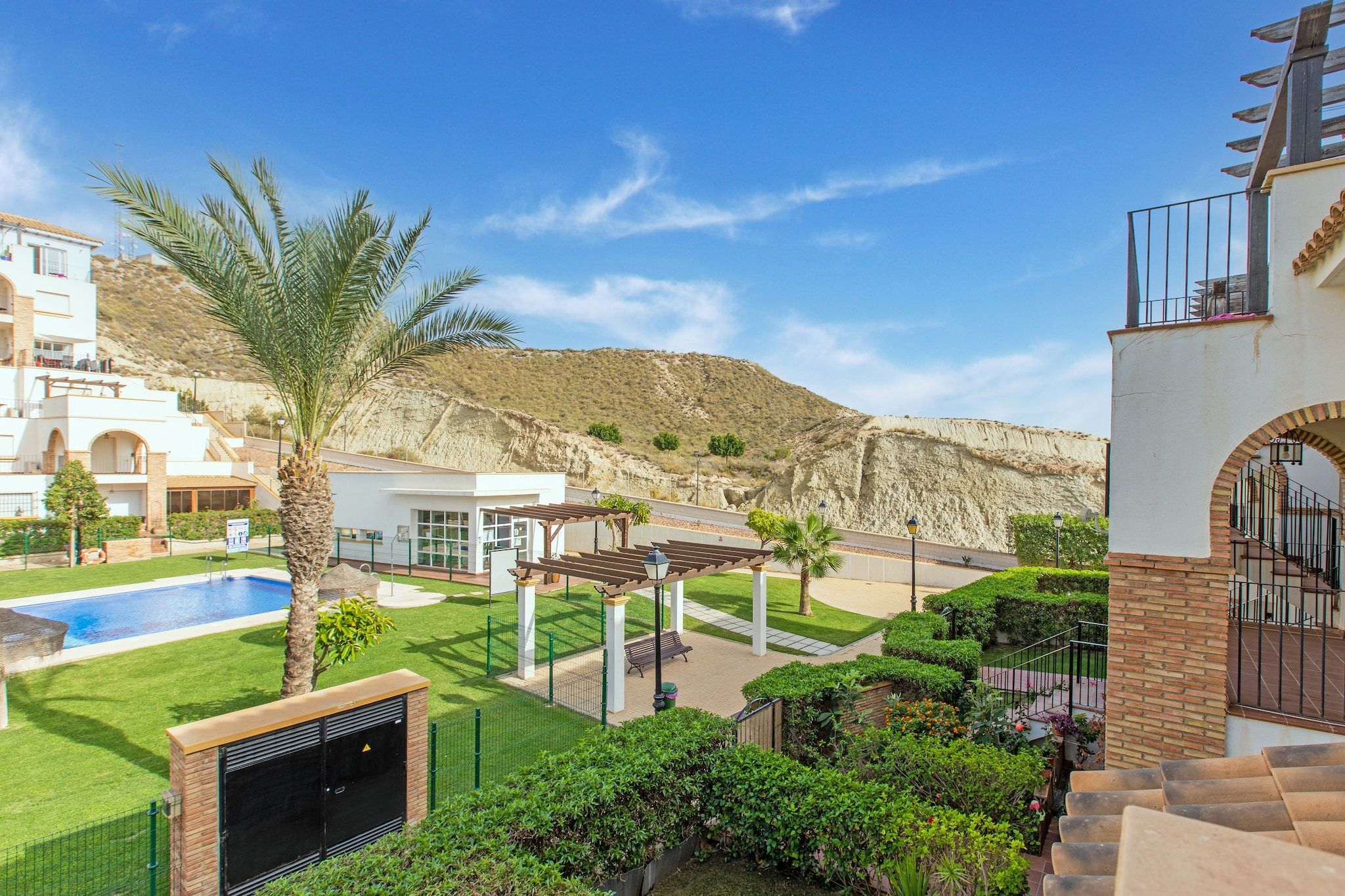Un quartier résidentiel doté d’une piscine, d’une pergola et offrant une vue sur un paysage montagneux.