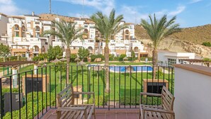 Zona residencial con piscina, palmeras y vistas a edificios de apartamentos.
