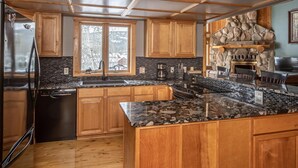 A modern kitchen with wooden cabinets, a stone backsplash, and a built-in island.