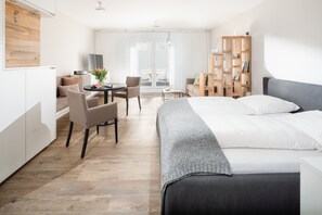 Une chambre d’hôtel moderne équipée d’un lit, d’un bureau, d’une chaise et d’une bibliothèque.
