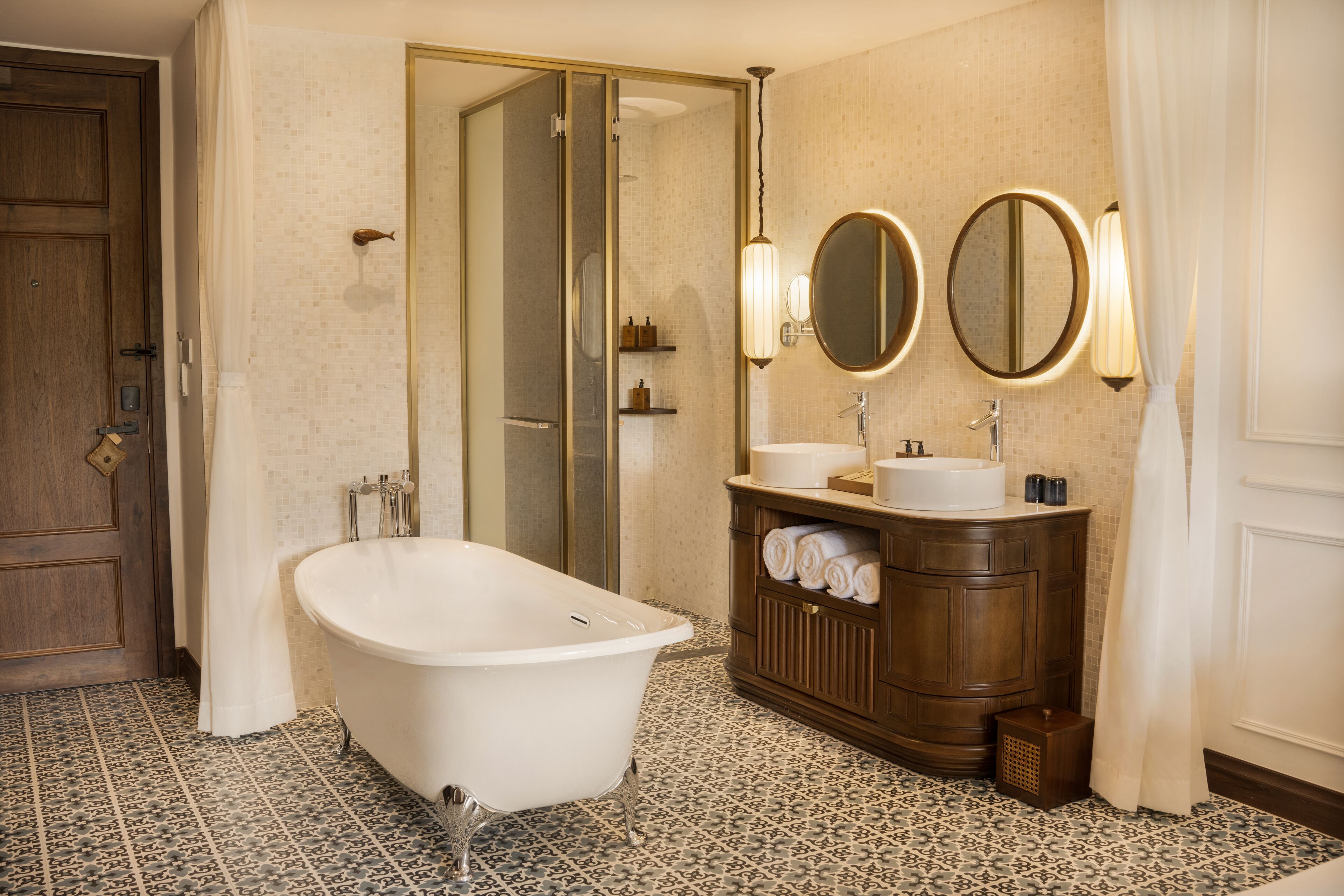 Une salle de bain avec une baignoire sur pieds, un meuble-lavabo avec un miroir et un espace douche.