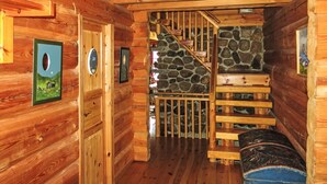 A wooden cabin interior with a staircase leading to a stone wall. - Lindefjeldbu by Interhome (Eikerapen)
