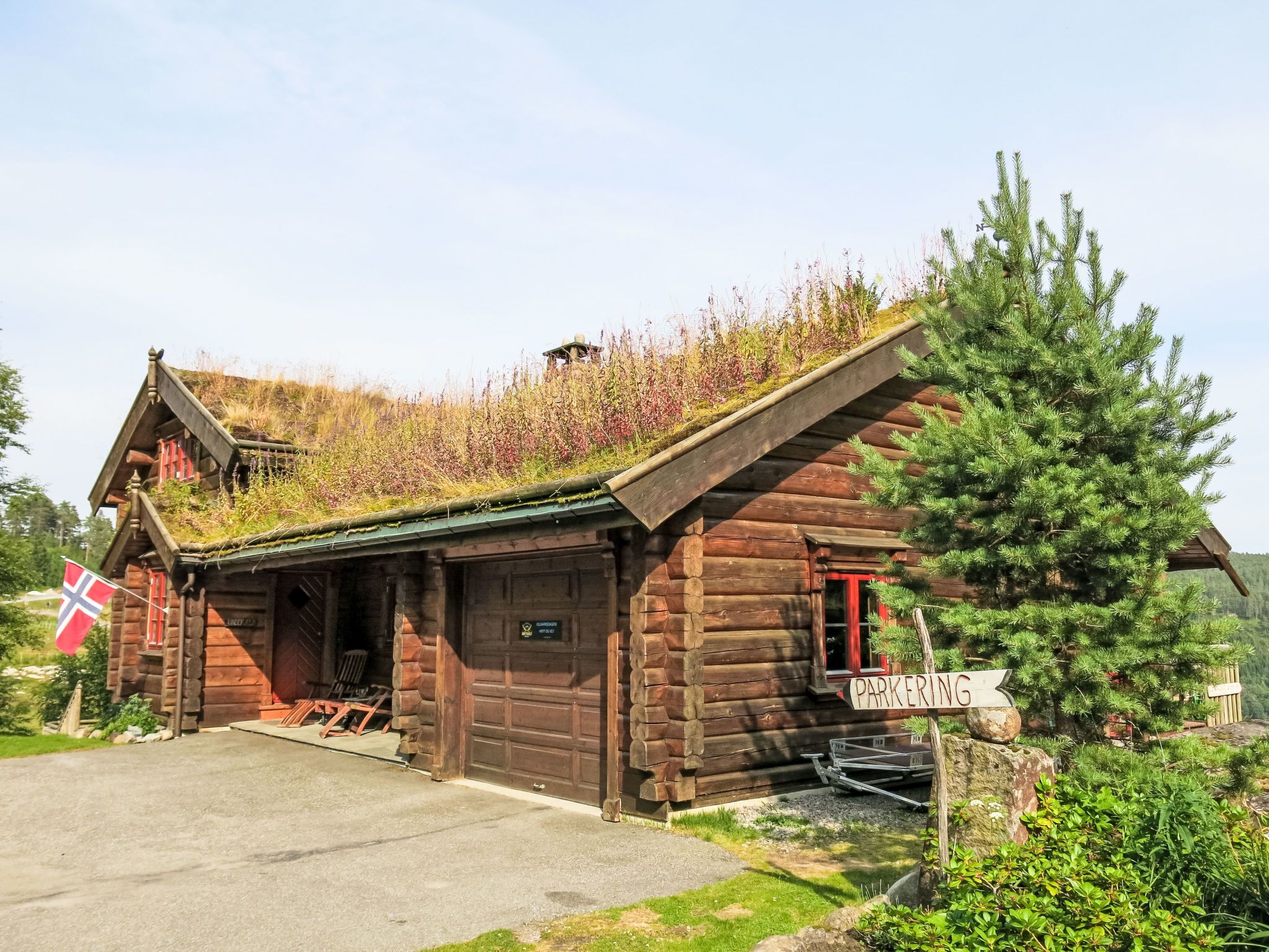 Une cabane en bois avec un toit vert et un drapeau.