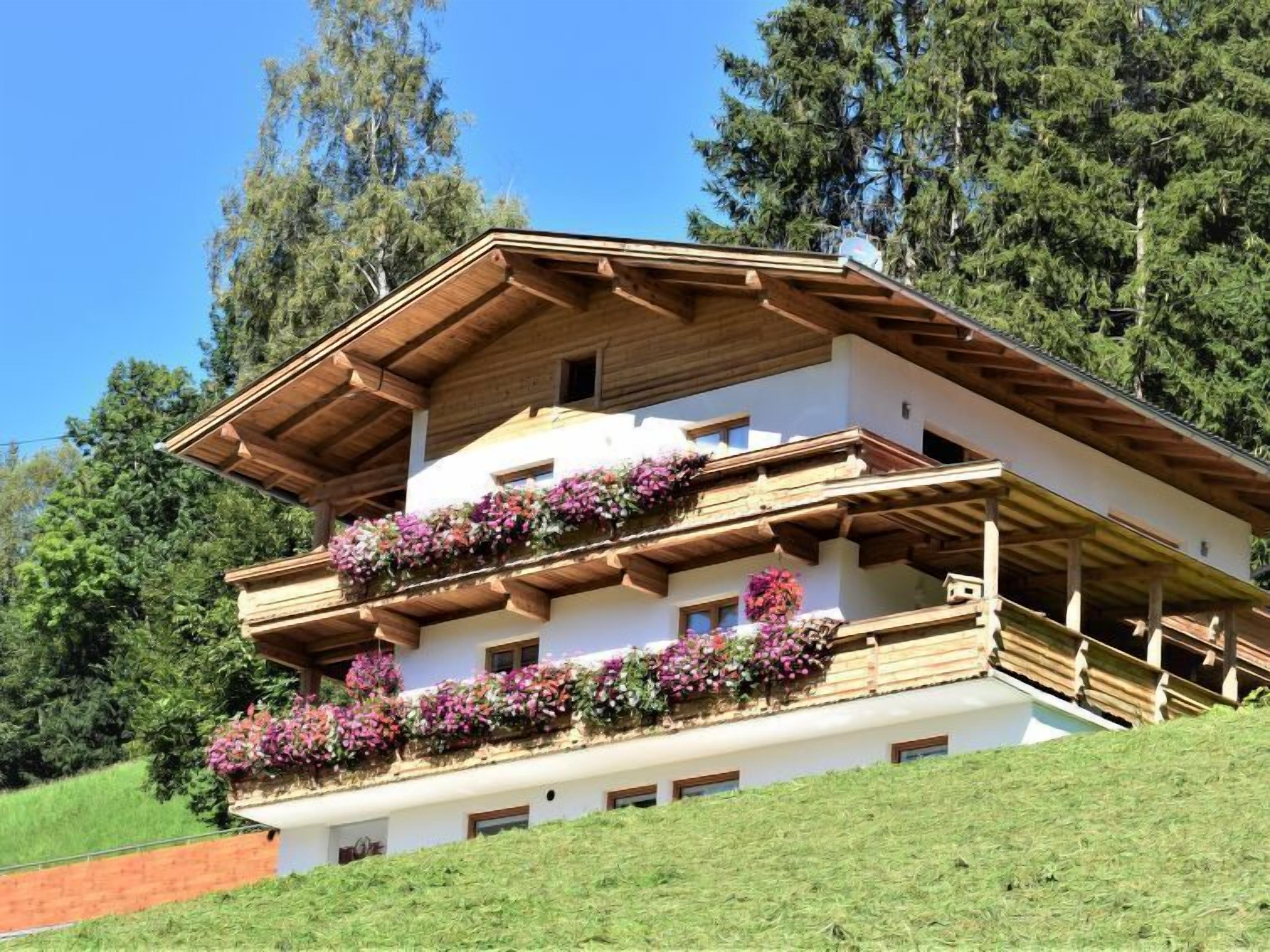 A multi-story chalet with wooden balconies and flower boxes.