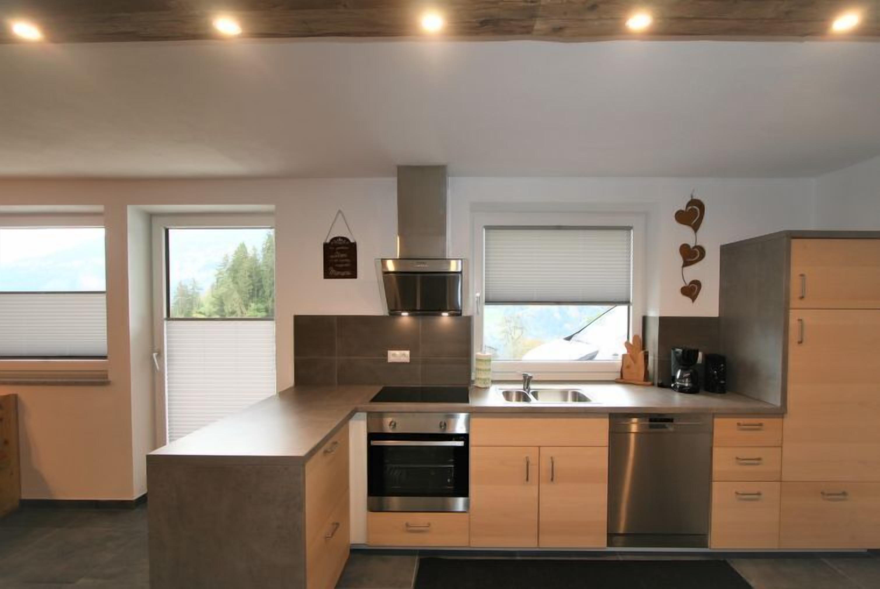 Una cocina moderna con una isla central, electrodomésticos de acero inoxidable y armarios de madera.