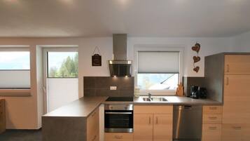 Una cocina moderna con una isla central, electrodomésticos de acero inoxidable y armarios de madera.
