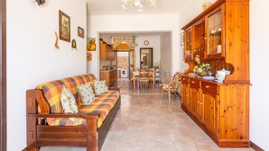 A cozy living room with a sofa, wooden cabinets, and a dining area. - 3032 Casa di Ada by Barbarhouse (Manduria)