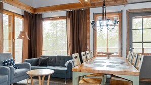 A dining area with a wooden table and chairs, a sofa, and a lamp.