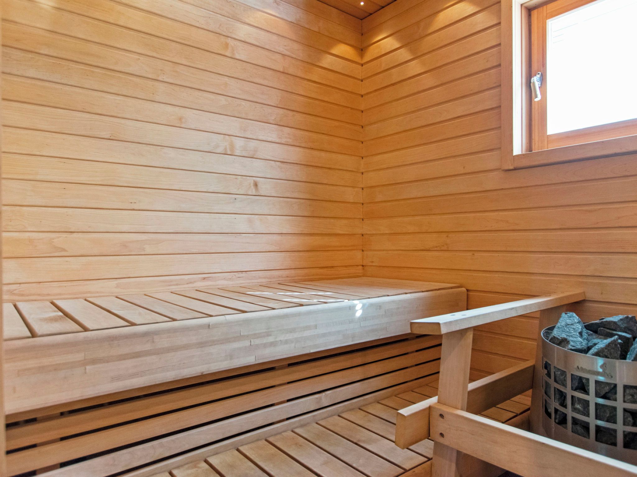 A sauna room with wooden benches and a window.