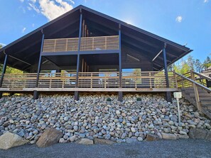 A modern building with a wooden deck and a stone foundation.