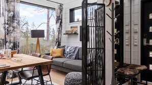 A modern interior with a dining area, sofa, and a decorative black partition. - Levi secret igloo revontuli 10d by Interhome (Kittilä)
