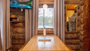 Een houten eettafel met banken in een eenvoudige houten hut.