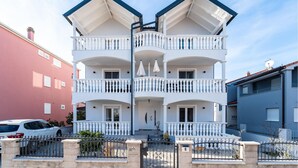 A multi-story building with a symmetrical facade, balconies, and a gated entrance. - Cozy apartment in Biograd na Moru with WiFi (Biograd na Moru)