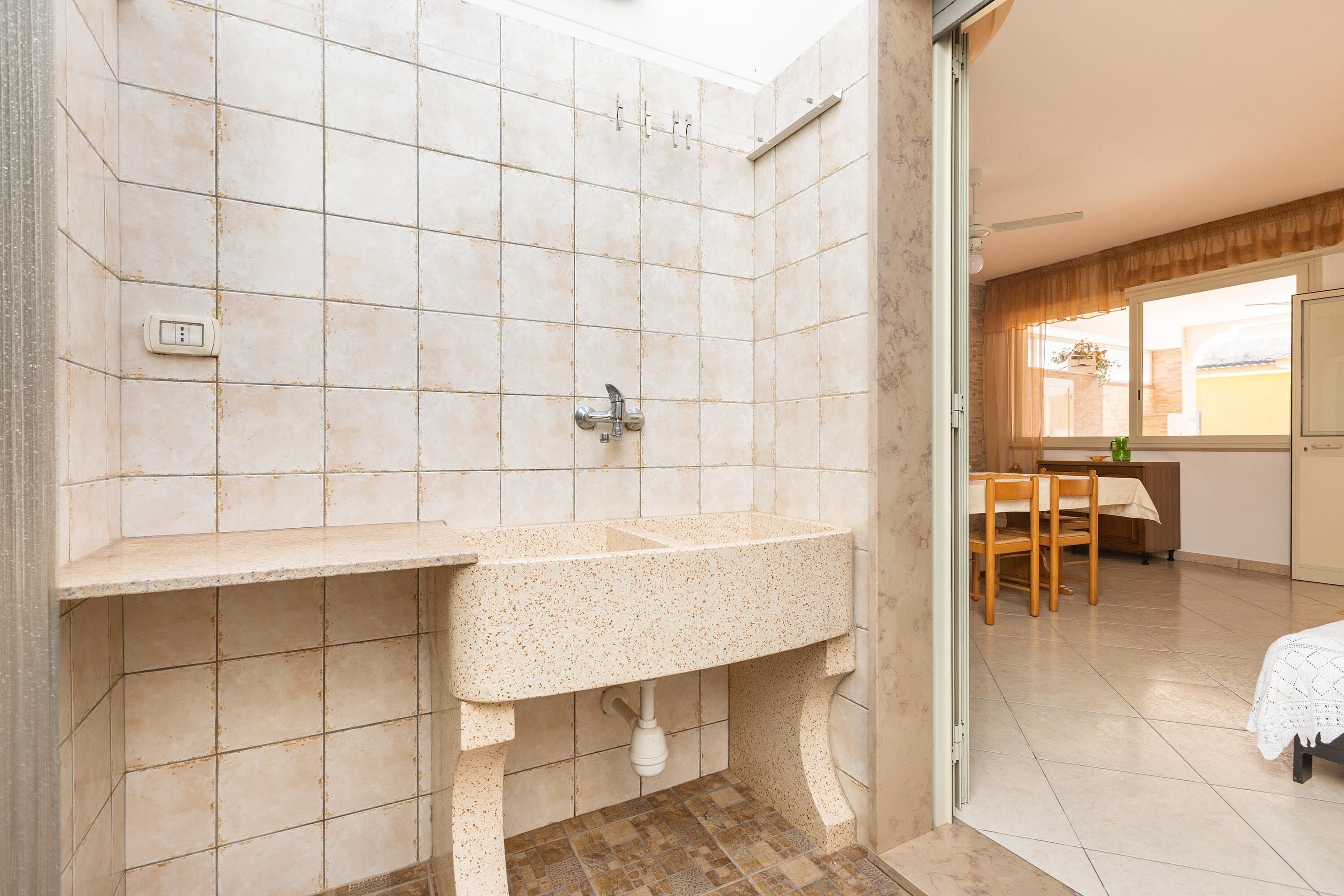 A bathroom with a sink, a shower, and a window.